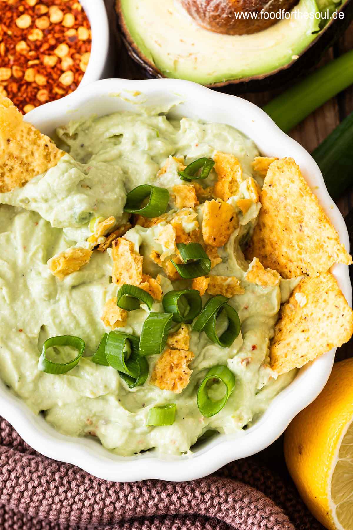 Avocado Dip mit Frischkäse in einer Schale serviert mit Tortilla Chips