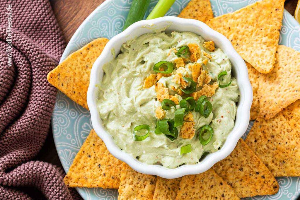 Avocado Dip mit Frischkäse in einer Schale serviert mit Tortilla Chips