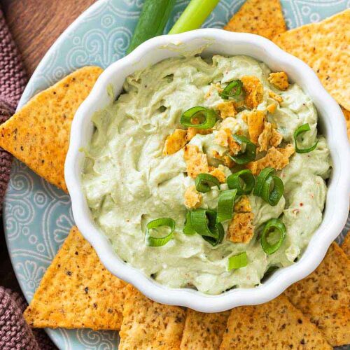 Avocado Dip mit Frischkäse in einer Schale serviert mit Tortilla Chips