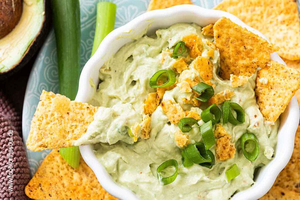 Avocado Dip mit Frischkäse in einer Schale serviert mit Tortilla Chips