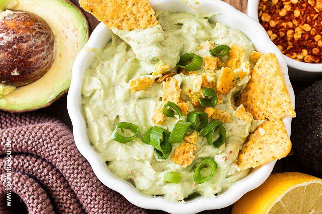 Avocado Dip mit Frischkäse in einer Schale serviert mit Tortilla Chips