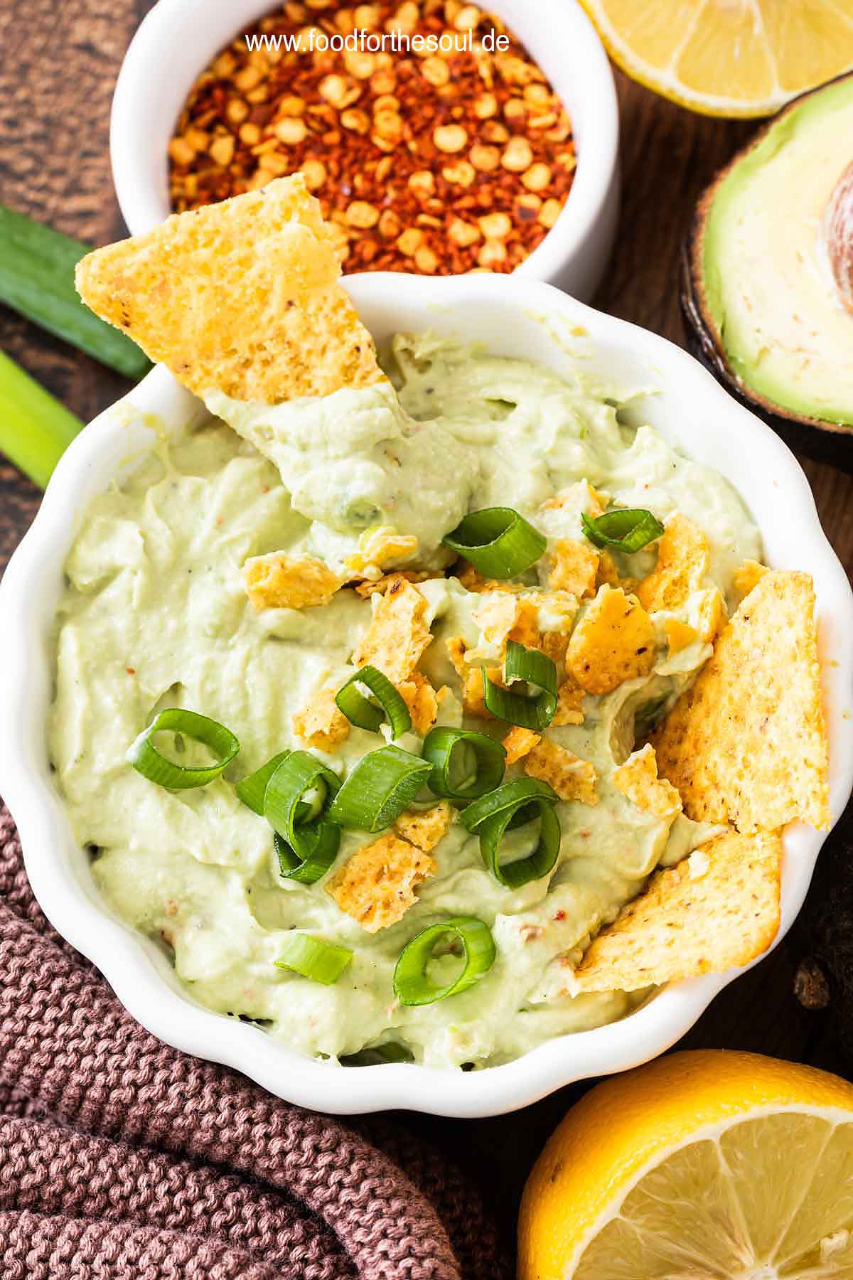 Avocado Dip mit Frischkäse in einer Schale serviert mit Tortilla Chips