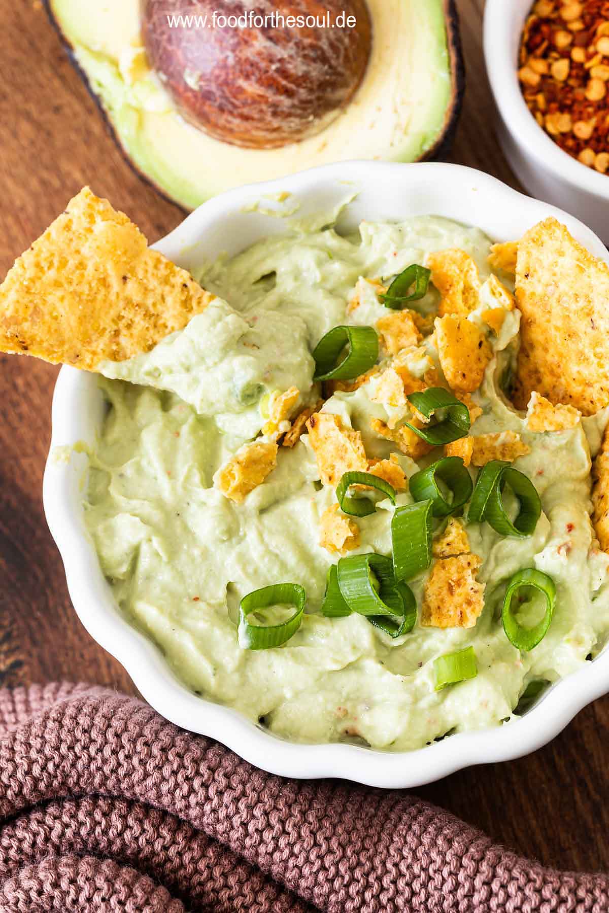 Avocado Dip mit Frischkäse in einer Schale serviert mit Tortilla Chips