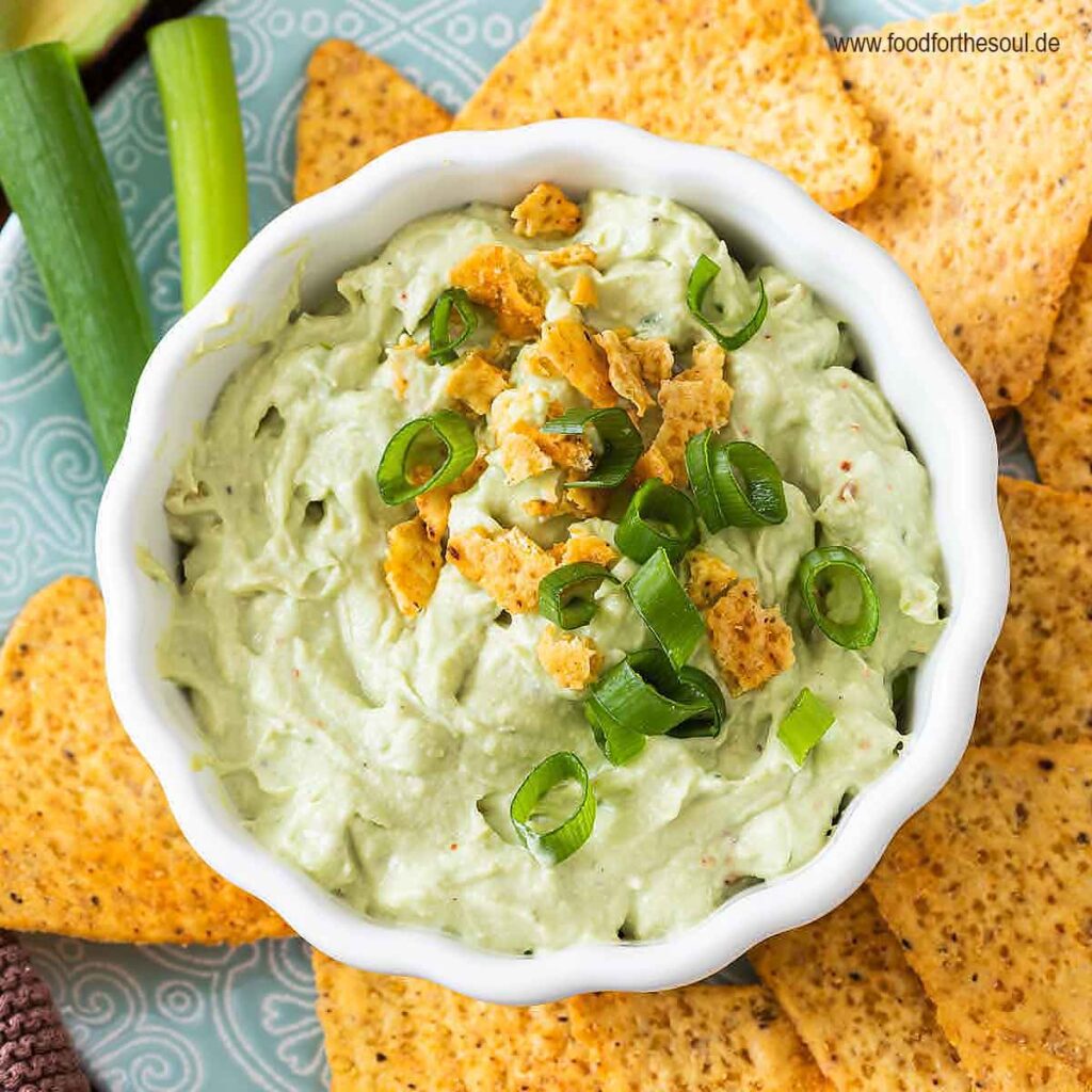 Avocado Dip mit Frischkäse in einer Schale serviert mit Tortilla Chips