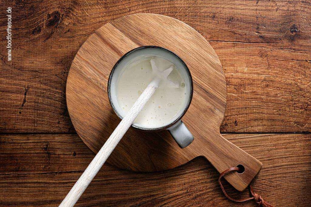 Sahne und Mehl in einer Tasse mit Quirl
