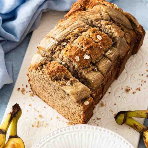Bananenbrot mit Haferflocken serviert auf einem Frühstücksbrett