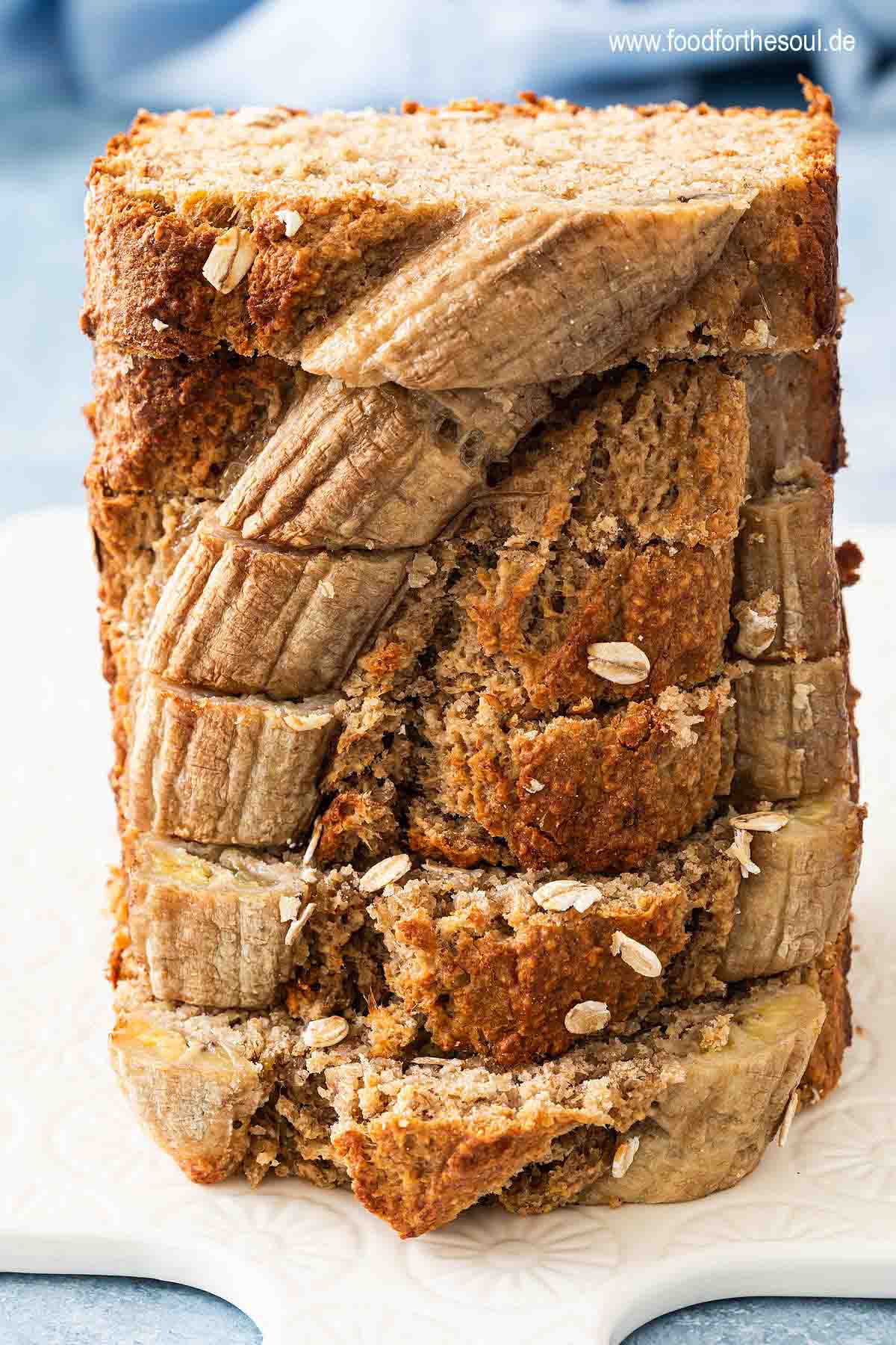 6 Scheiben Bananenbrot mit Haferflocken gestapelt auf einem Frühstücksbrett