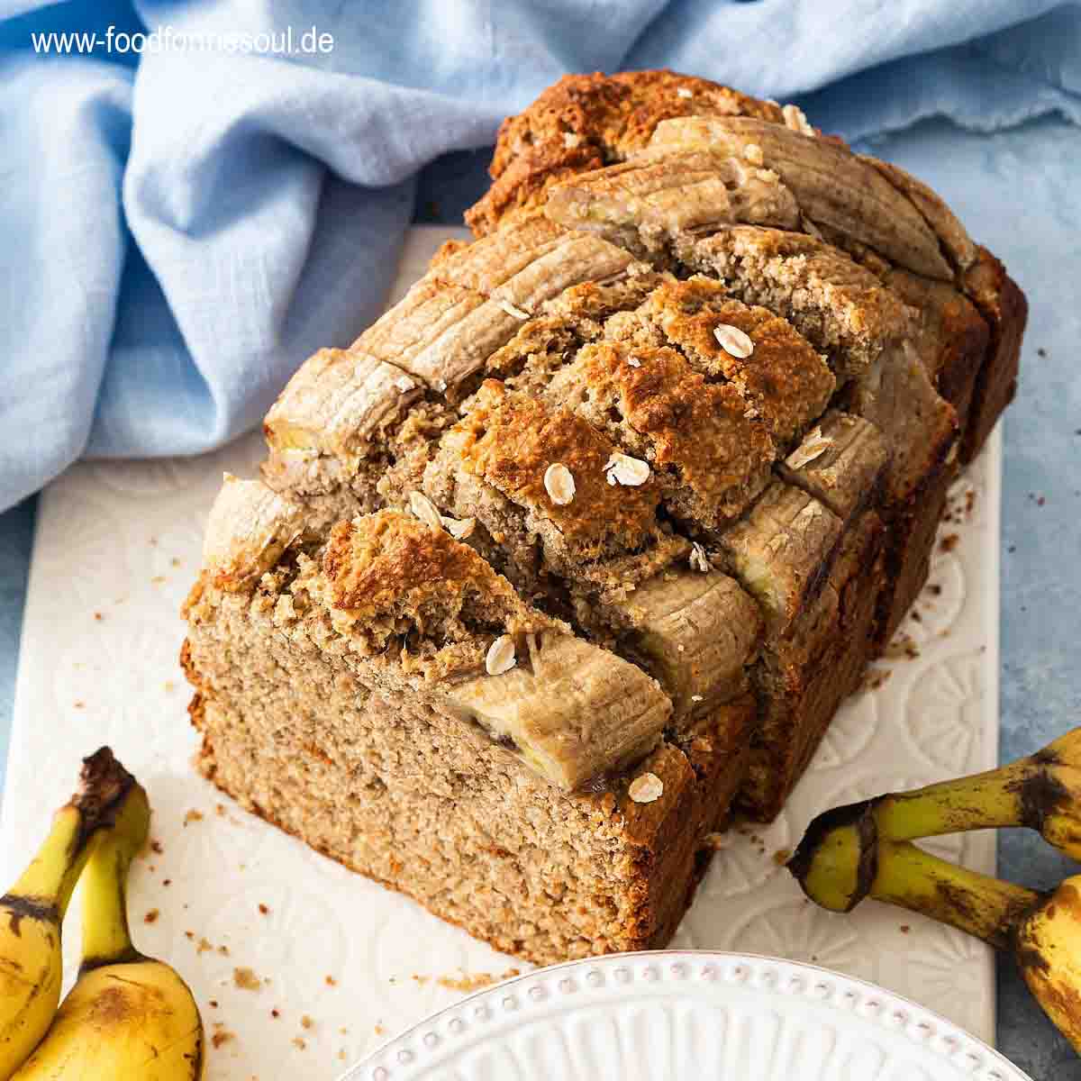 Bananenbrot mit Haferflocken serviert auf einem Frühstücksbrett