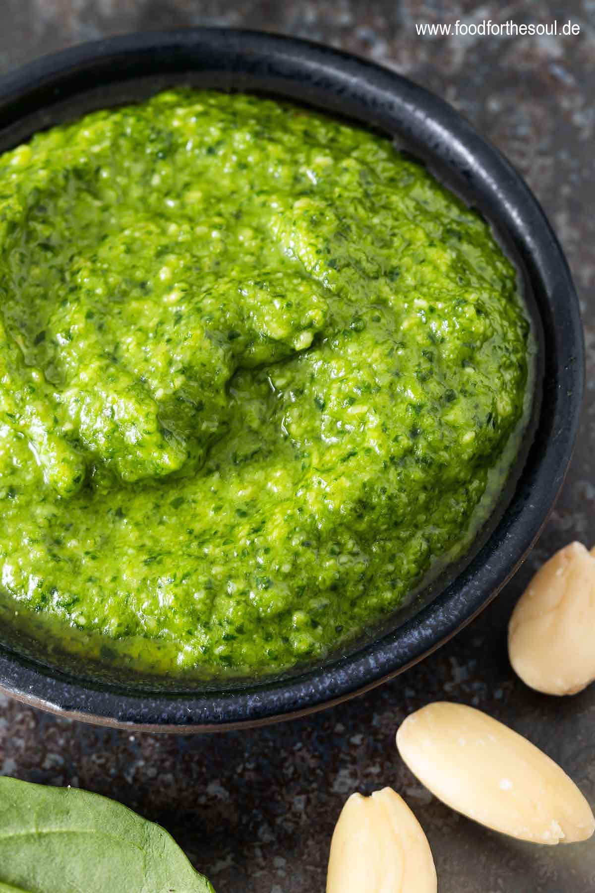 Spinat Pesto in einer Schale, daneben Mandeln
