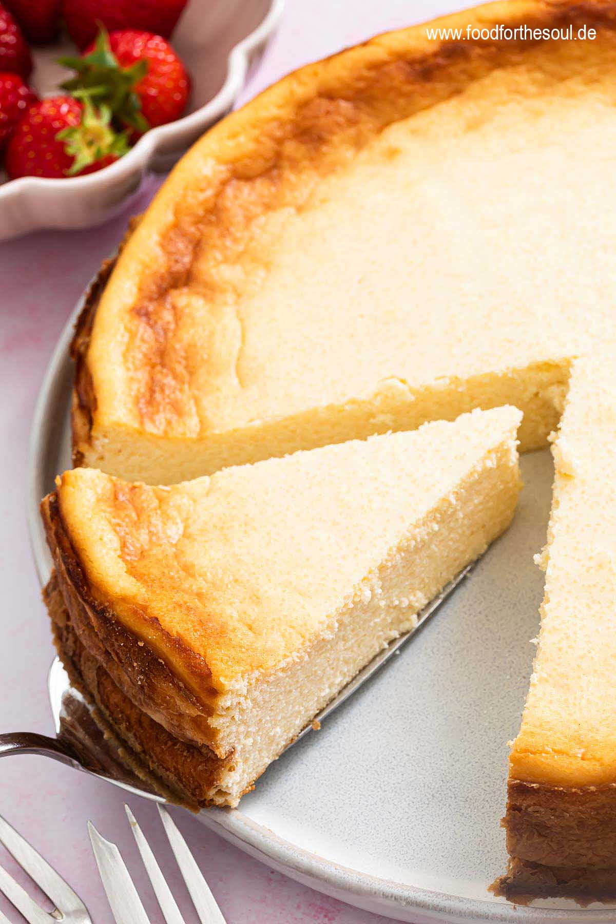 Ein Stück Quarkkuchen ohne Boden mit Grieß auf einem Teller mit Tortenheber