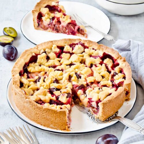 Omas Zwetschgenkuchen mit Streusel auf Mürbeteig auf einem Kuchenteller