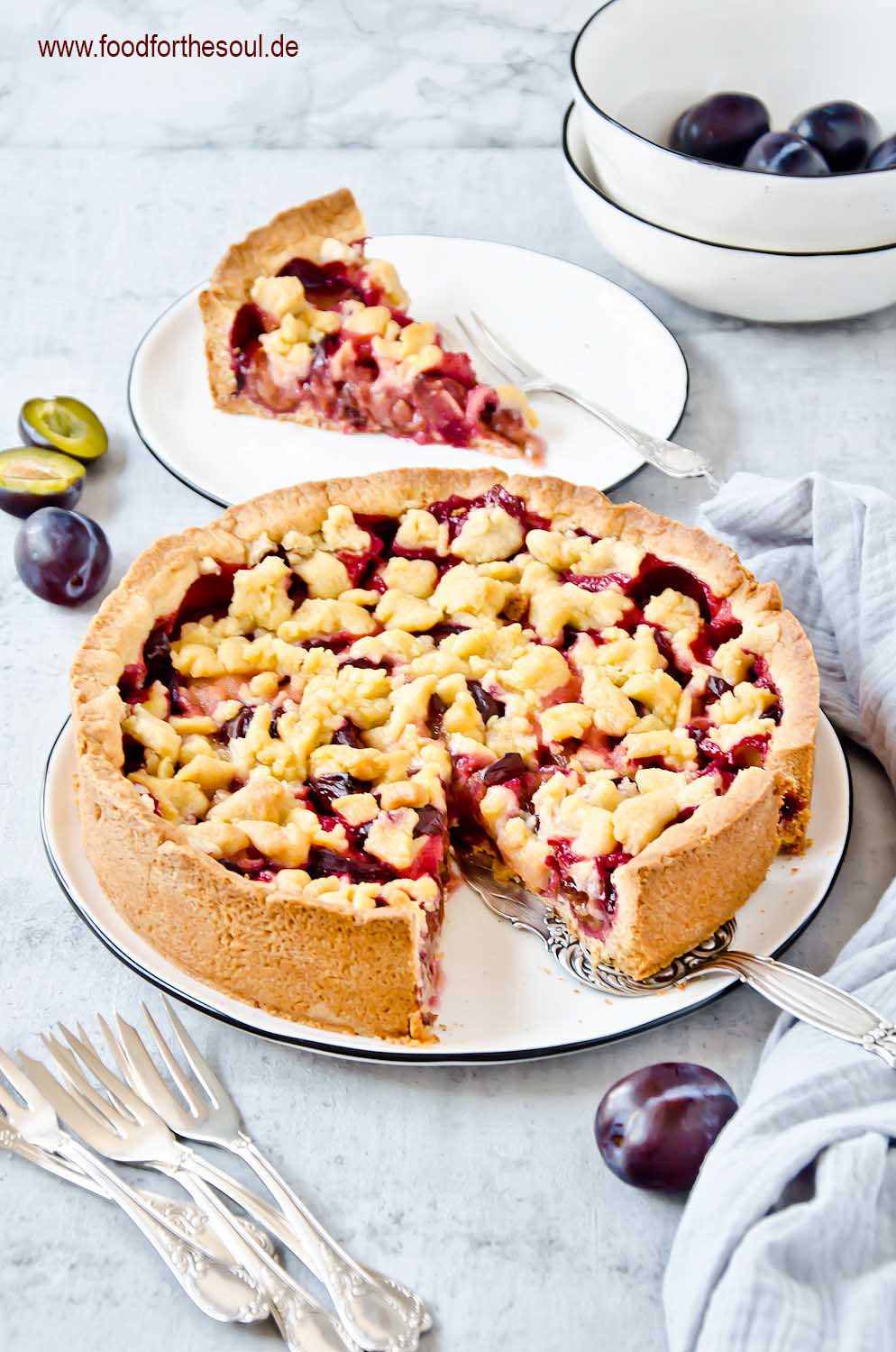 Omas Zwetschgenkuchen mit Streusel auf Mürbeteig auf einem Kuchenteller