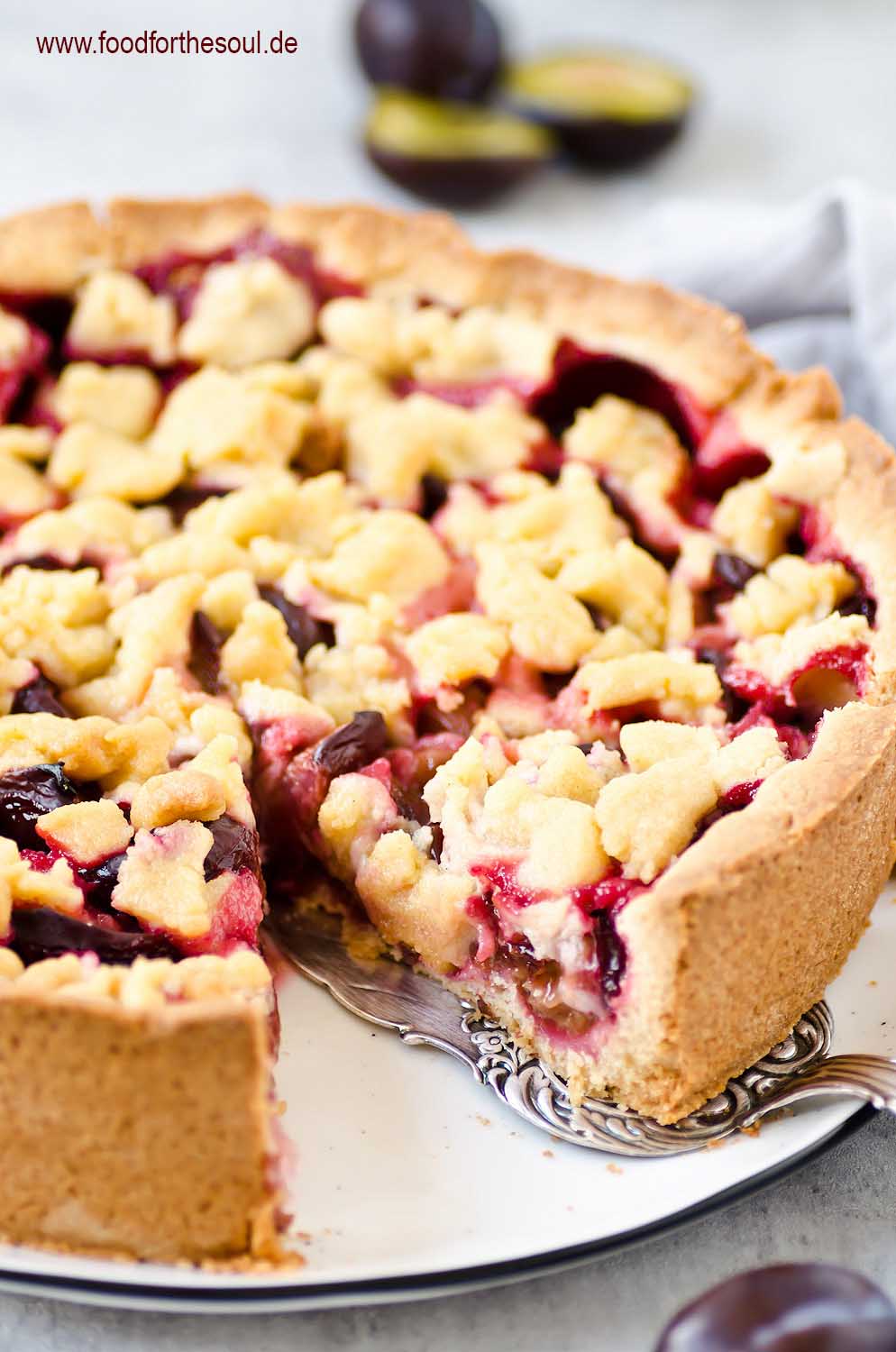 Omas Zwetschgenkuchen mit Streusel auf Mürbeteig auf einem Kuchenteller