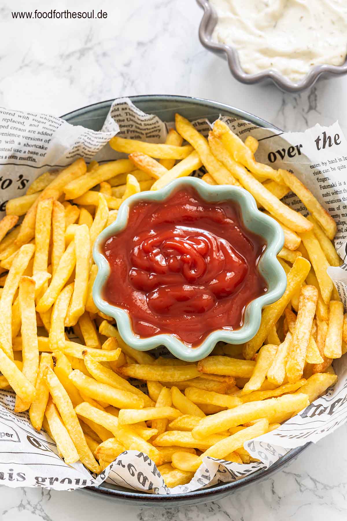TK Pommes aus dem Airfryer in einer Schale angerichtet mit Ketchup, daneben eine Schale mit Mayonnaise