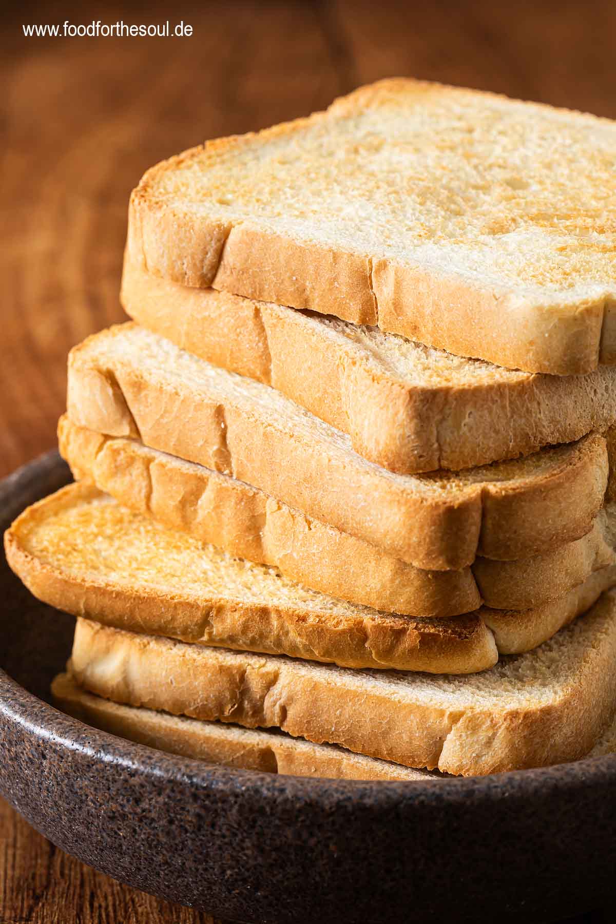 Mehrere Scheiben Toastbrot iin der Heißluftfritteuse getoastet und in einer Schale gestapelt