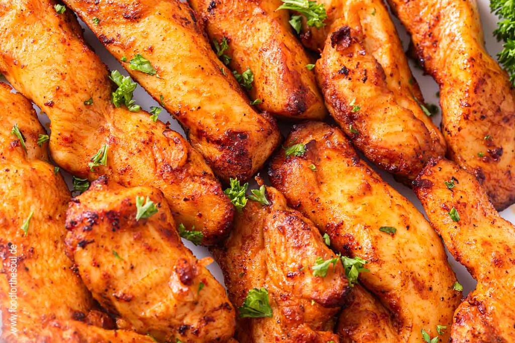 Hähnchenbruststreifen im Airfryer zubereitet und mit Kräutern bestreut