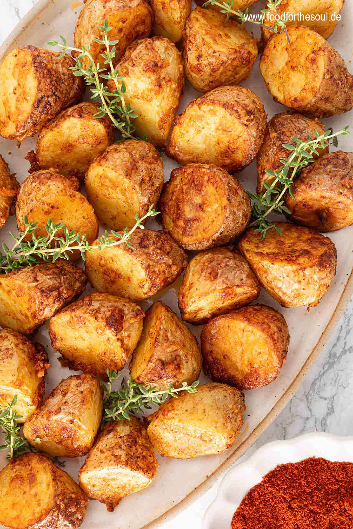 Airfryer Kartoffeln mit knuspriger Parmesan Kruste angerichtet auf einer Servierschale