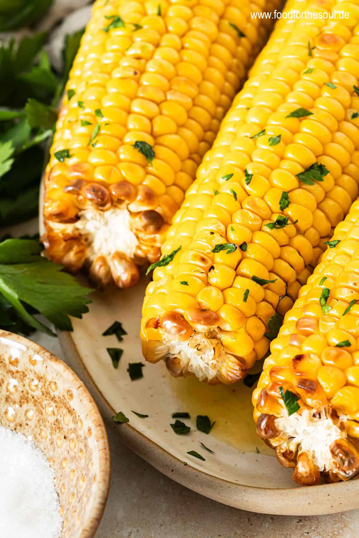 Maiskolben im Airfryer zubereitet und serviert mit Butter und Petersilie