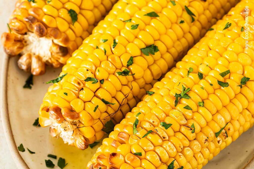 Maiskolben im Airfryer zubereitet und serviert mit Butter und Petersilie