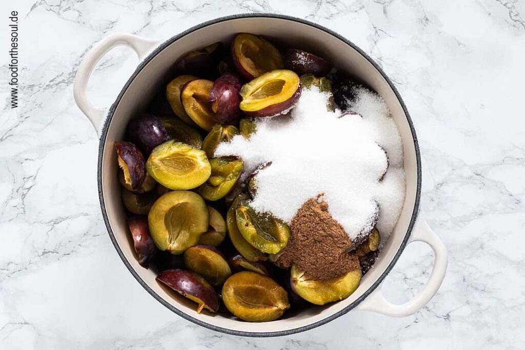Zucker und Gewürze werden Zwetschgen hinzugefügt für Pflaumenmus im Backofen nach Omas Rezept - Schritt 3