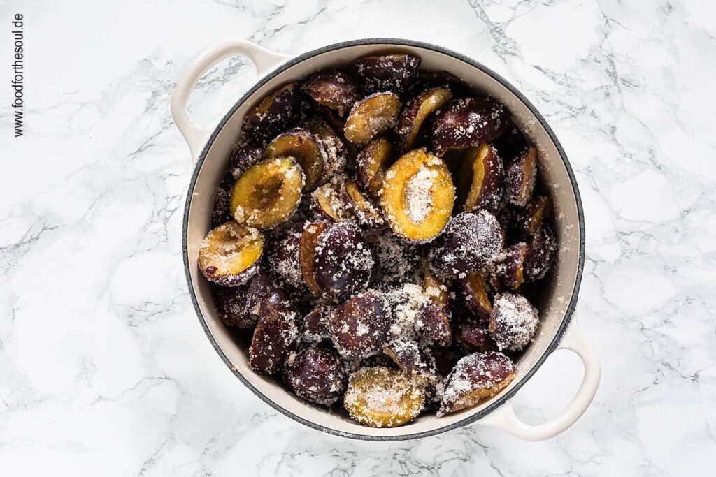 Zwetschgen zuckern in einem Gusseisentopf für Pflaumenmus im Backofen nach Omas Rezept - Schritt 4