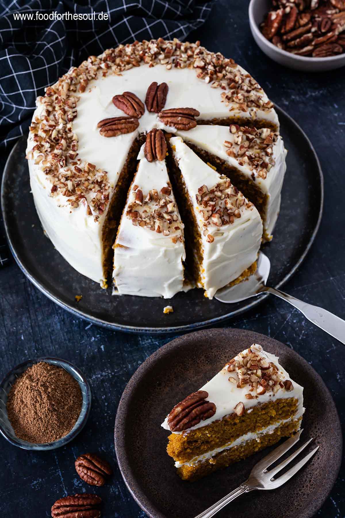 Amerikanischer Kürbiskuchen mit Frischkäse Frosting und Pecan Nüssen serviert auf einem Kuchenteller