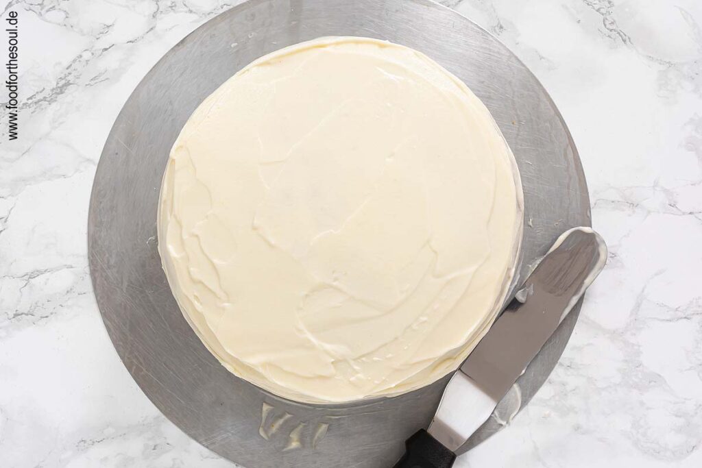 Zweiten Boden auf ersten setzen und Kürbiskuchen mit Frischkäse Frosting einstreichen - Schritt 13