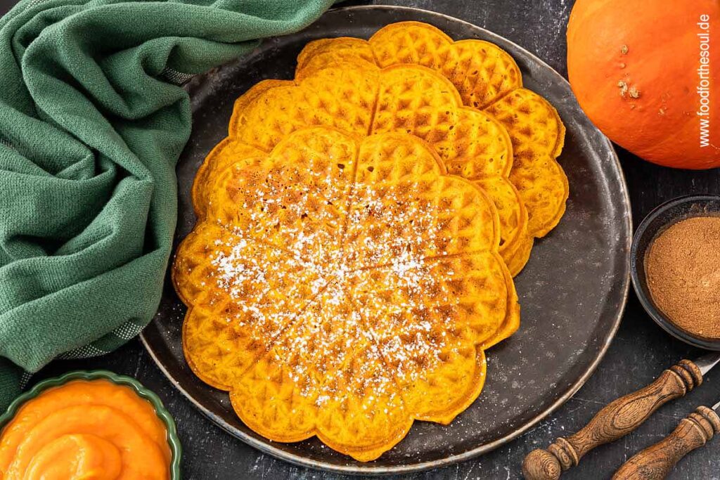 Kürbiswaffeln mit Puderzucker bestreut und serviert auf einem Teller
