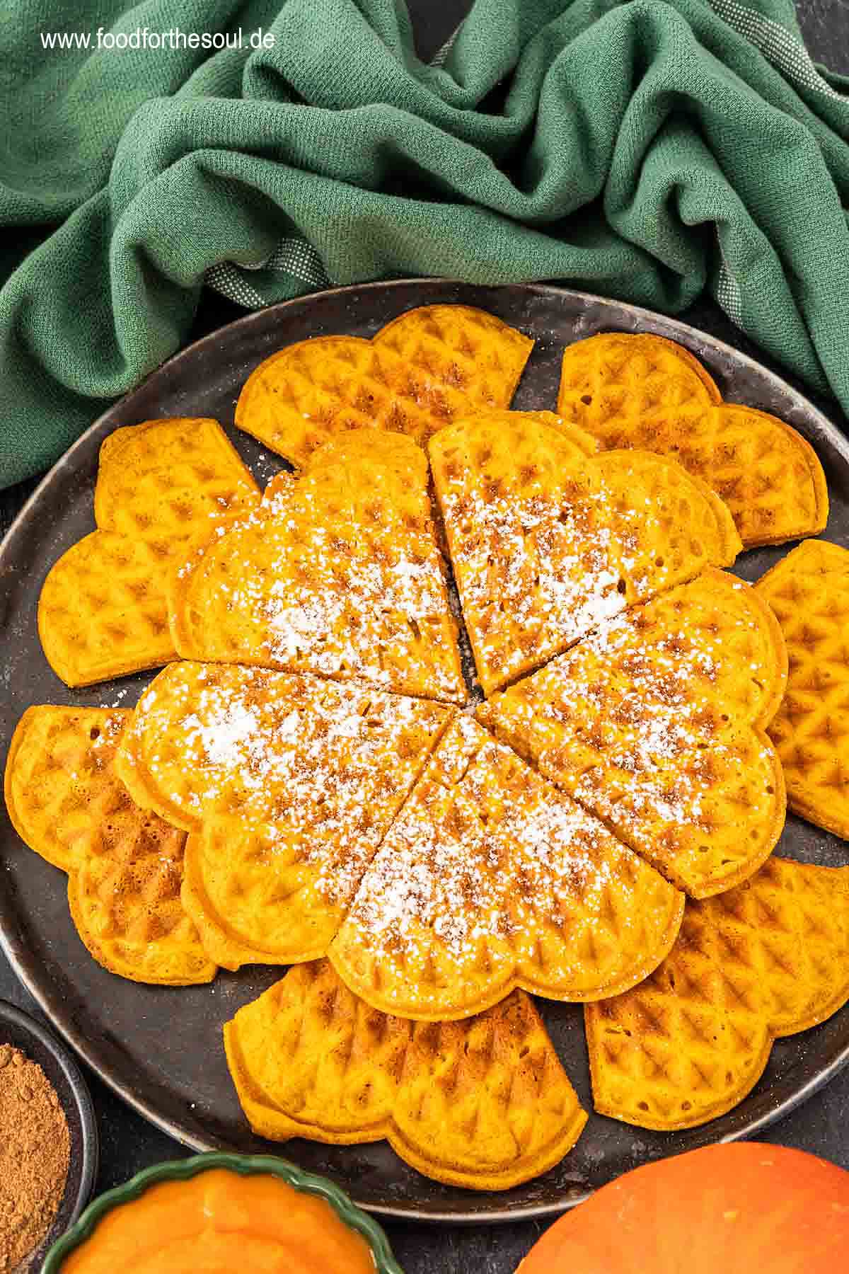 Kürbiswaffeln mit Puderzucker bestreut und serviert auf einem Teller