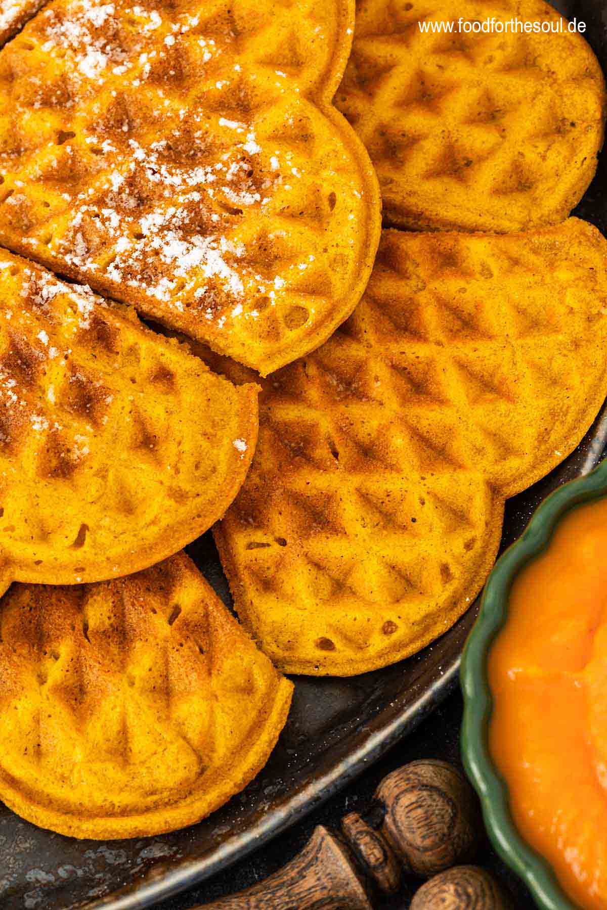 Kürbiswaffeln mit Puderzucker bestreut und serviert auf einem Teller