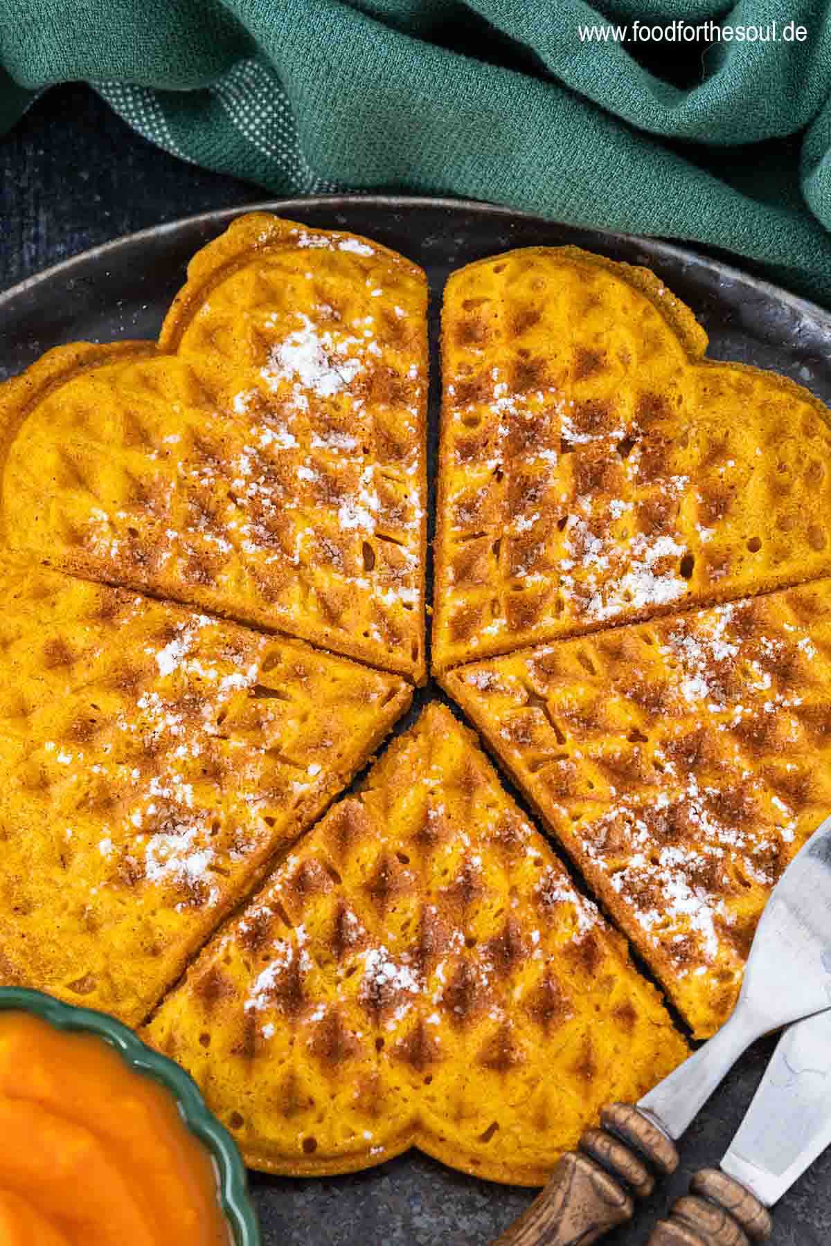 Kürbiswaffeln mit Puderzucker bestreut und serviert auf einem Teller