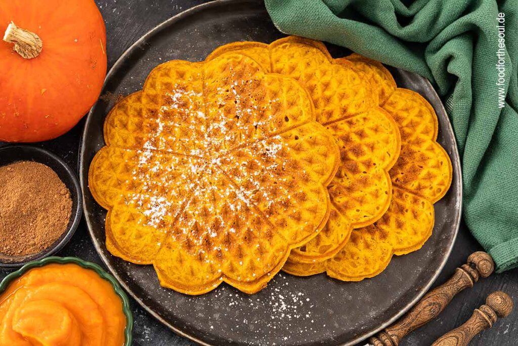 Kürbiswaffeln mit Puderzucker bestreut und serviert auf einem Teller