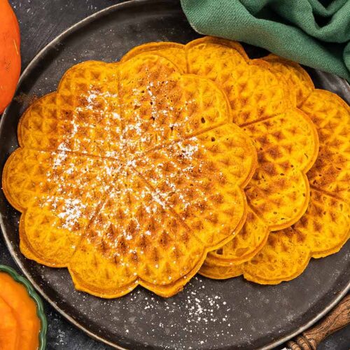 Kürbiswaffeln mit Puderzucker bestreut und serviert auf einem Teller