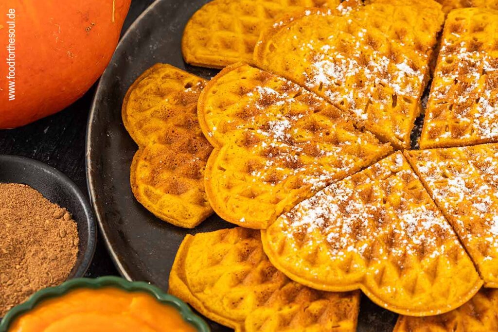 Kürbiswaffeln mit Puderzucker bestreut und serviert auf einem Teller