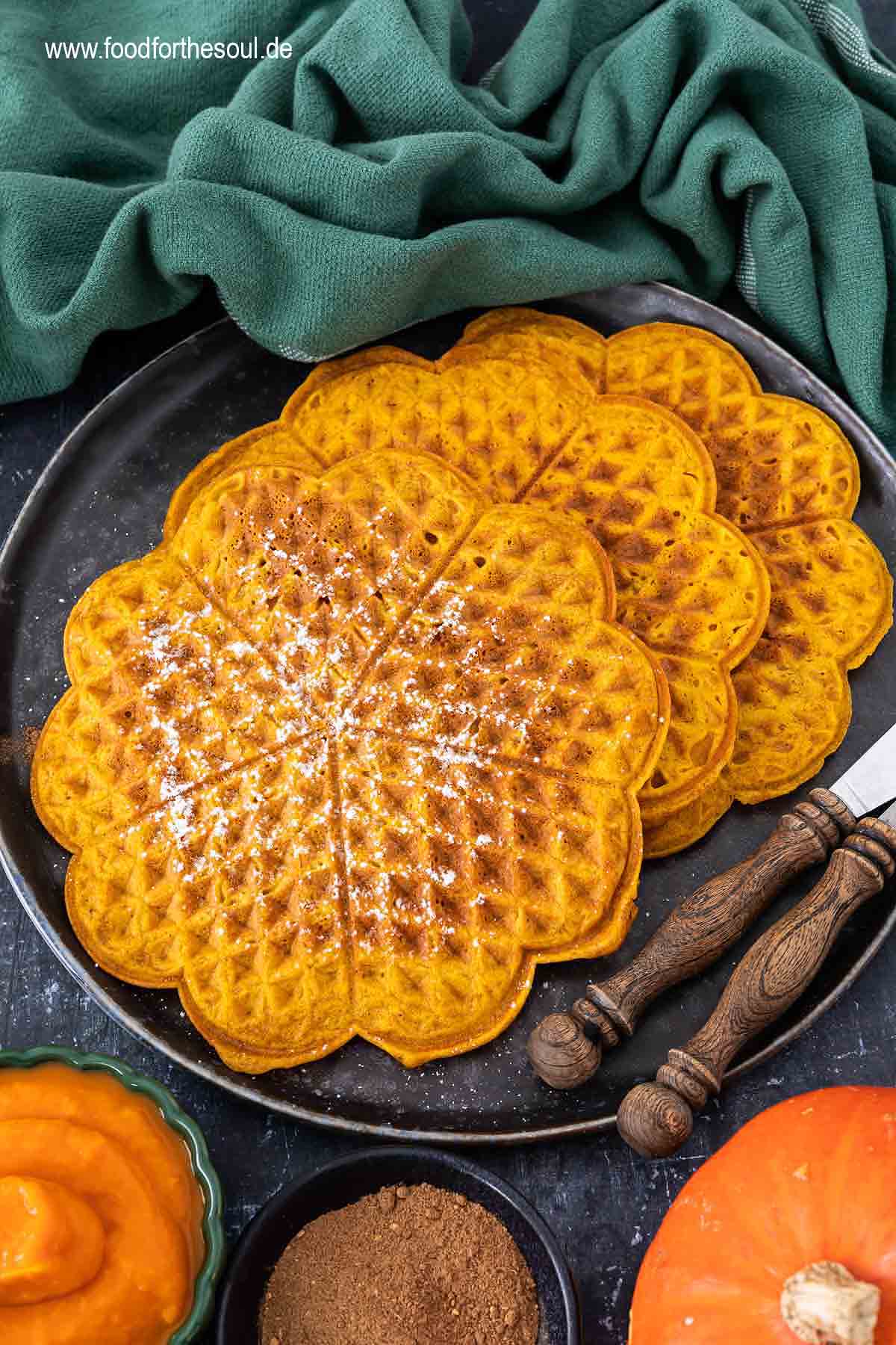 Kürbiswaffeln mit Puderzucker bestreut und serviert auf einem Teller