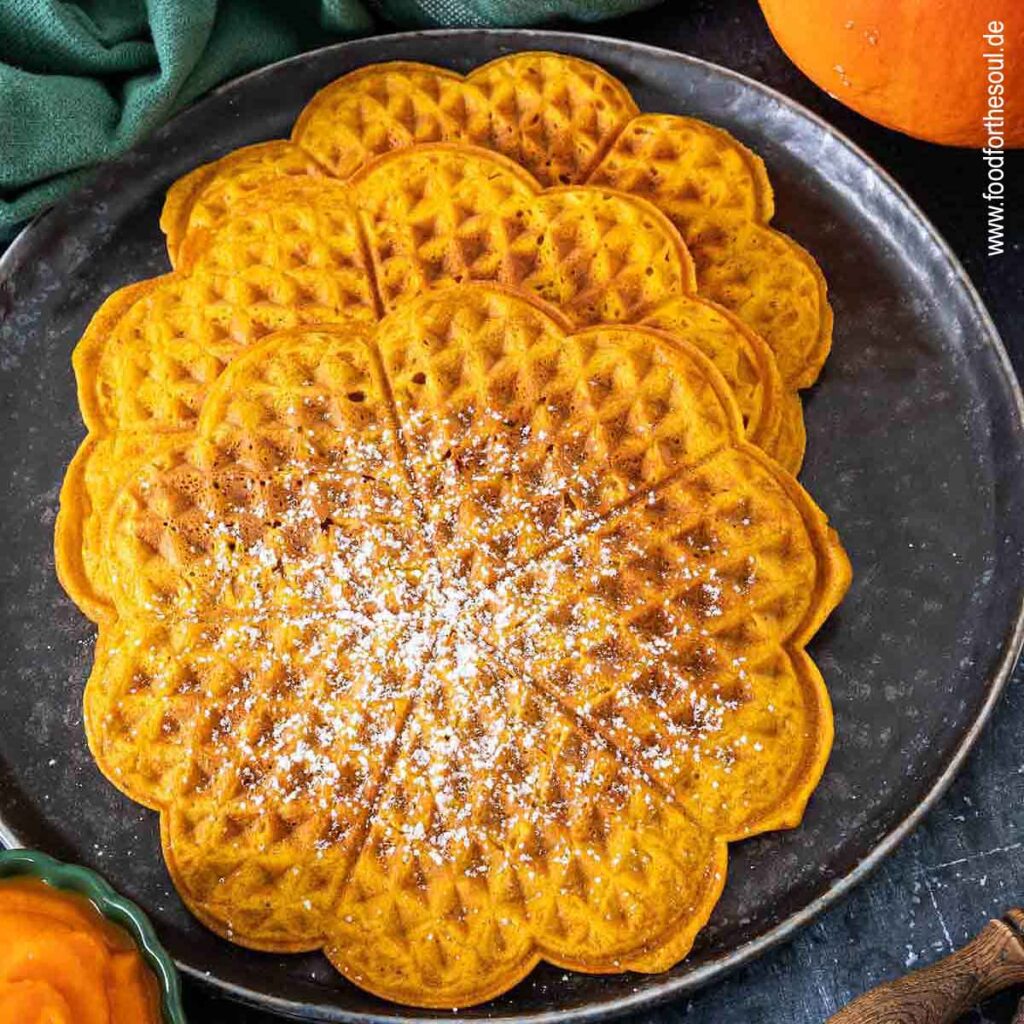 Kürbiswaffeln mit Puderzucker bestreut und serviert auf einem Teller