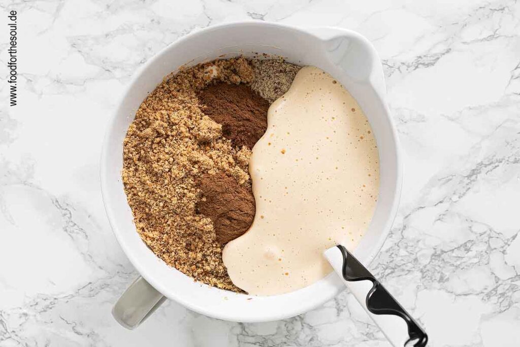 Eimasse mit Gewürzen und gemahlenen Nüssen verrühren - Schritt 3