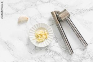 Knoblauch durch eine Knoblauchpresse drücken - Schritt 2