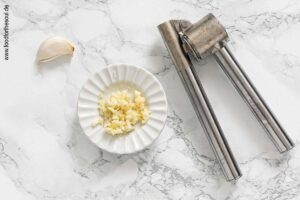 Knoblauch durch eine Knoblauchpresse drücken - Schritt 1