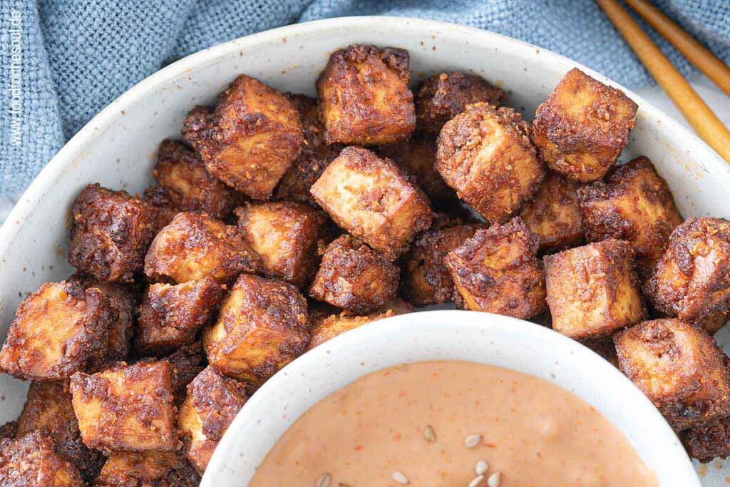 Im Airfryer geröstete Tofu-Würfel in einer Schale serviert mit Sriracha Mayo Dip