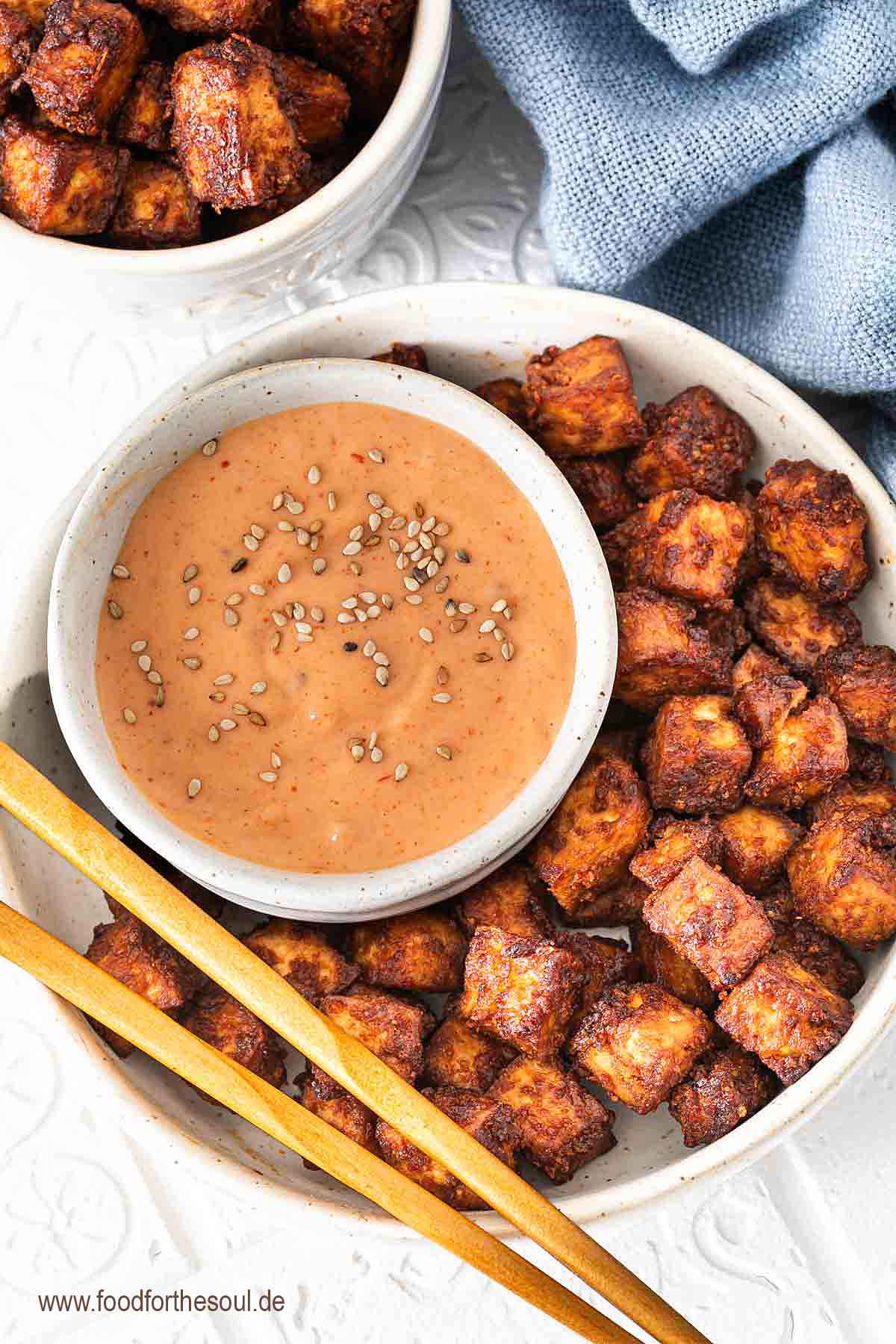 Im Airfryer geröstete Tofu-Würfel in einer Schale serviert mit Sriracha Mayo Dip