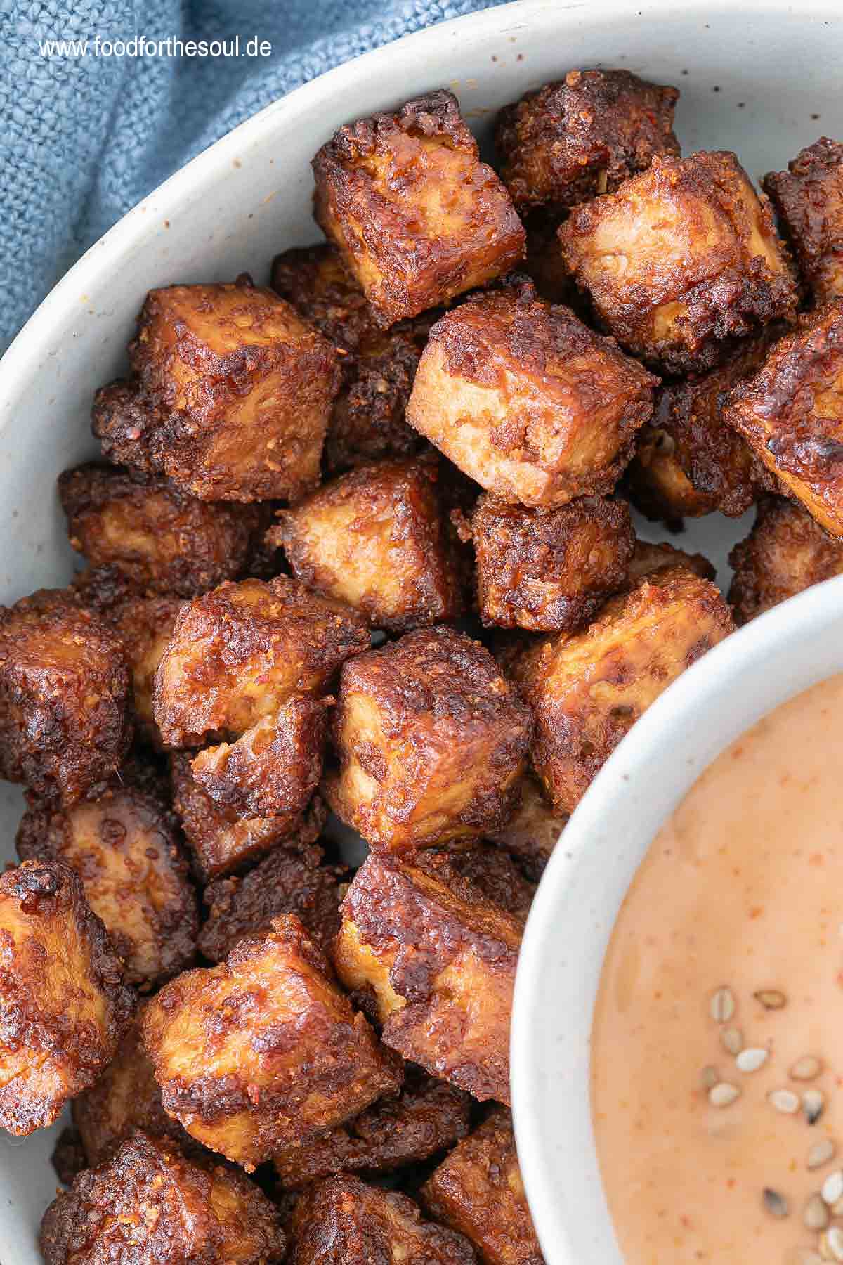 Im Airfryer geröstete Tofu-Würfel in einer Schale serviert mit Sriracha Mayo Dip