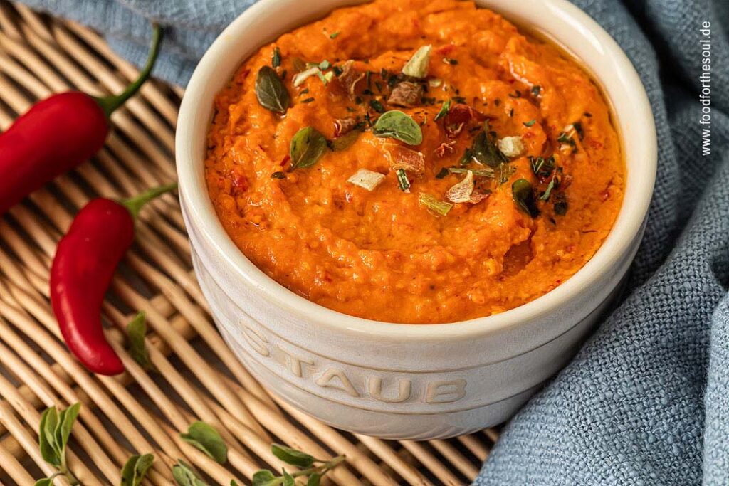 Paprika Pesto angerichetet in einer Schale und garniert mit Kräutern