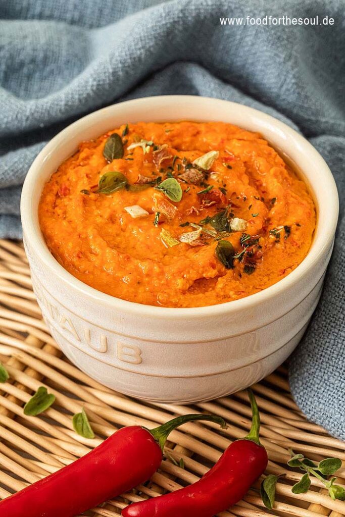 Paprika Pesto angerichetet in einer Schale und garniert mit Kräutern