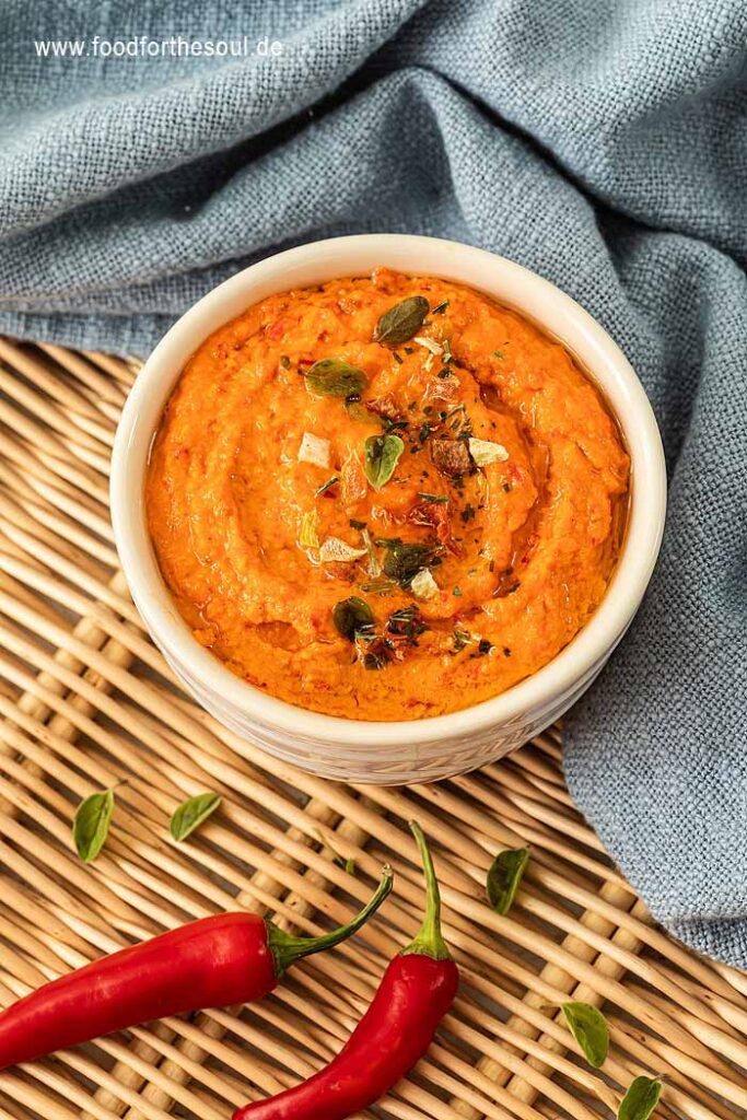 Paprika Pesto angerichetet in einer Schale und garniert mit Kräutern