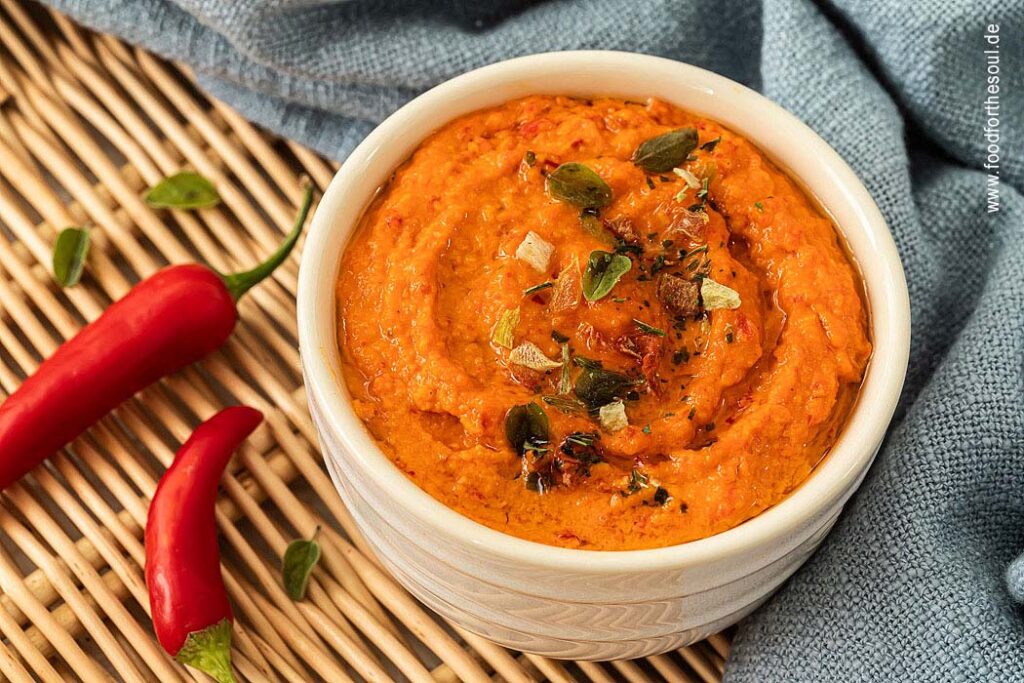 Paprika Pesto angerichetet in einer Schale und garniert mit Kräutern