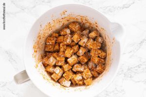 Speisestärke und Hefeflocken über marinierten Tofu geben und mischen - Schritt 3