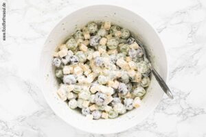 Trauben und Käse mit Dressing vermengen für Trauben-Käse-Salat