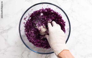 Gehobelten Rotkohl und Zwiebeln mit Salz kneten - Schritt 4