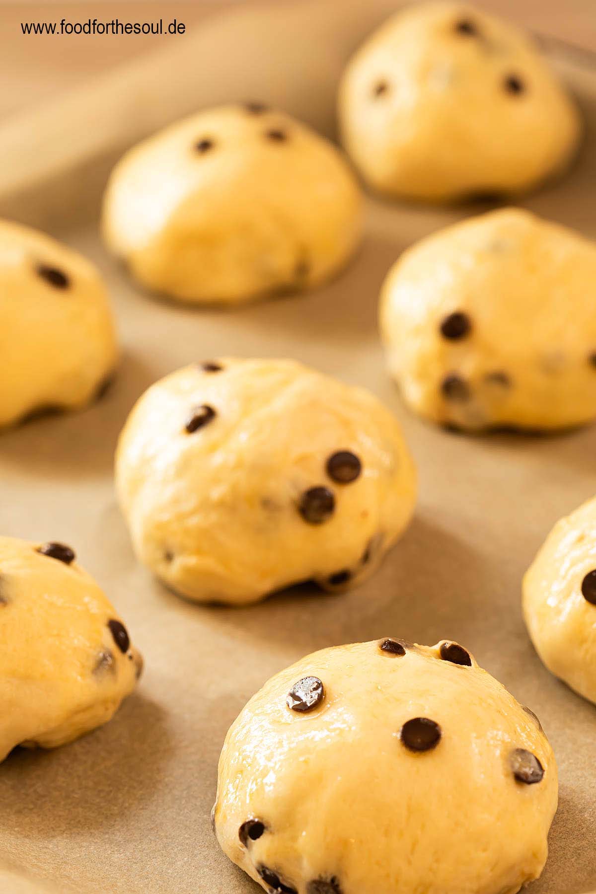 Ungebackene Schokobrötchen auf einem Backblech mit Backpapier